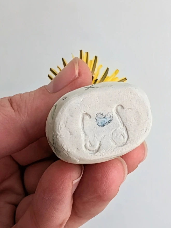  miniature vase held in a hand showing base with blue heart