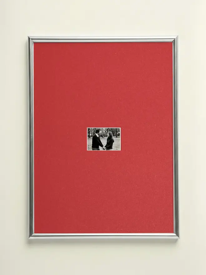 Vermillon mounted Silver Picture Frame, hanging on a red wall. 