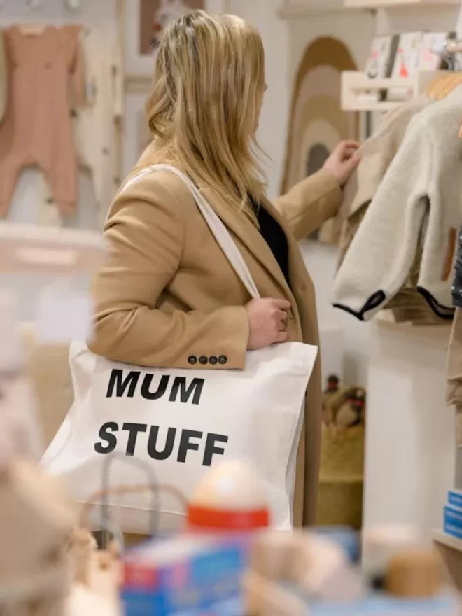 mum stuff natural canvas tote bag modelled by a woman shopping for a child