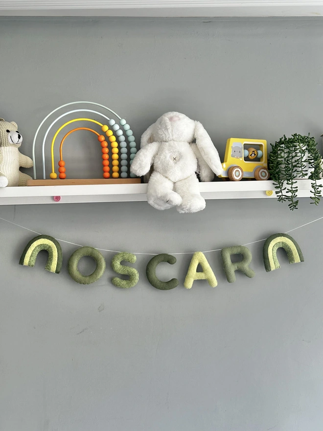 Personalised Name Icon Garland, a child’s name banner hanging from a white shelf, nursery decoration, baby gift 