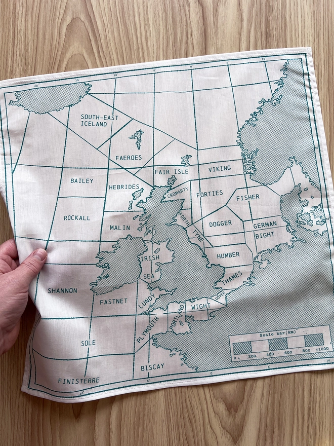 A Mr.PS green Shipping Handkerchief laid on a wooden table
