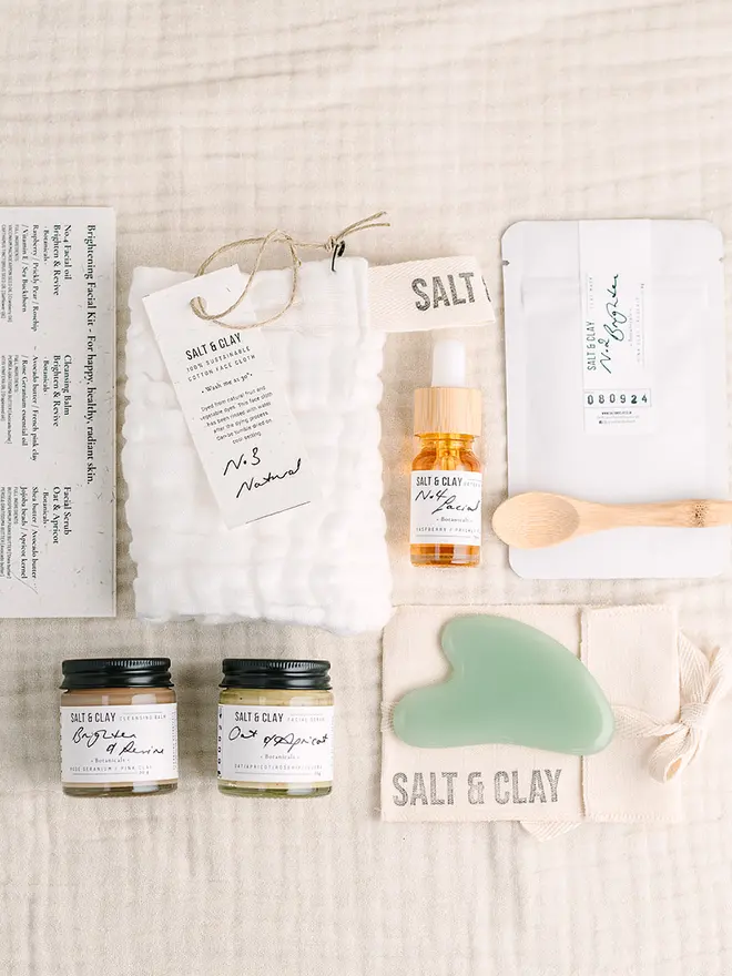 Skincare gift box of facial products including Gua Sha, facial oil, cleansing balm, cotton face cloth and clay face mask. skincare gift. Pampering gift.