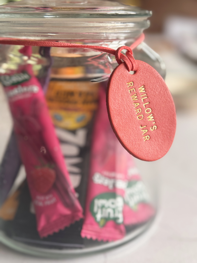 coral colour oval leather reward jar label in a glass jar