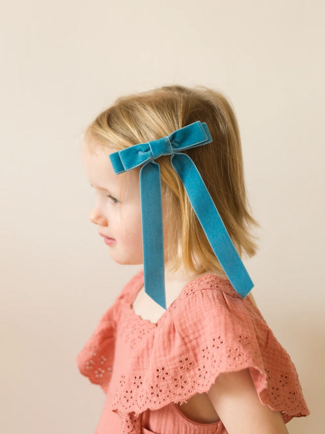 Girl wearing a bright blue velvet hair bow