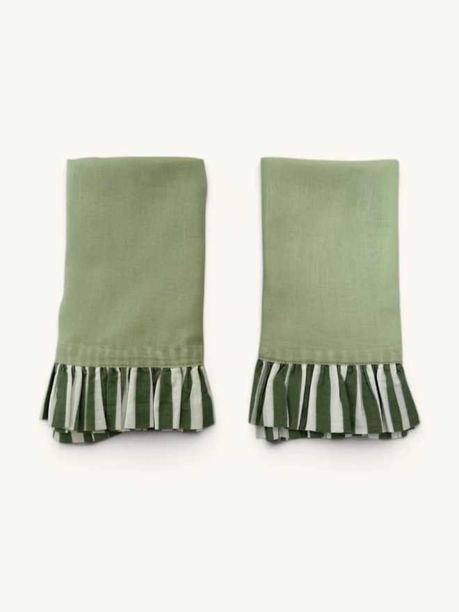 Pair of Ruffle Napkins. A pair of napkins, folded, in sage green and forest green.
