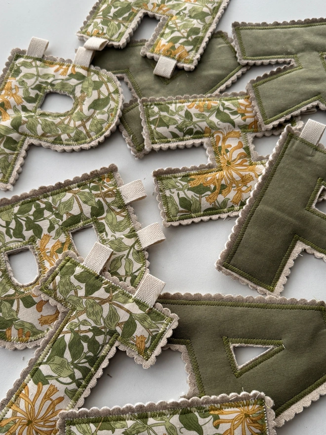 Green and golden yellow floral fabric letters scattered
