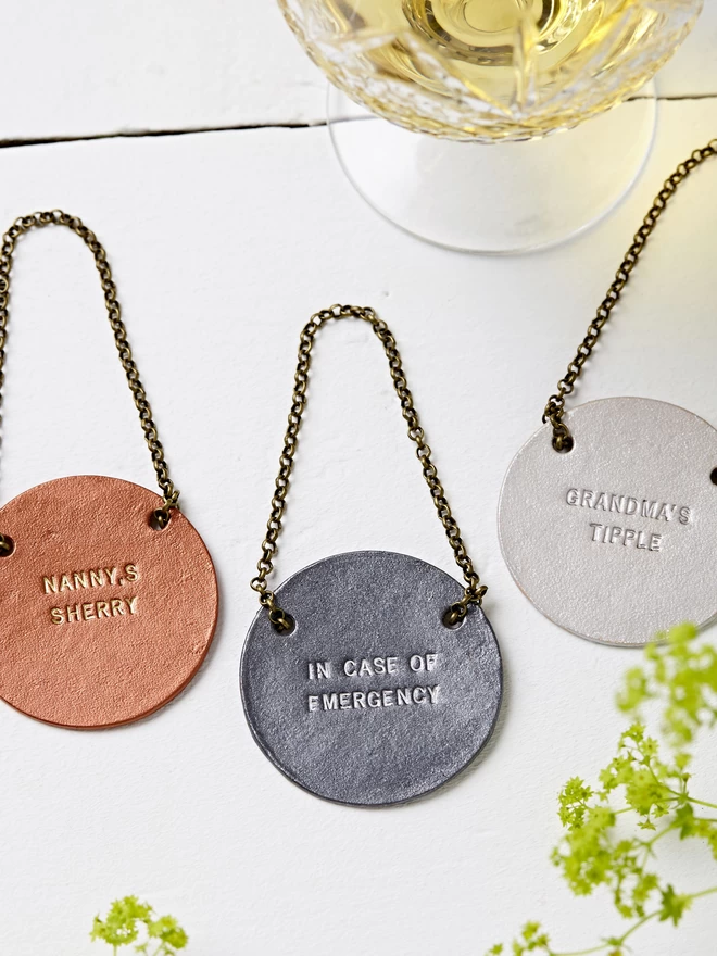Copper Pewter and Silver leather bottle tags that can be personalised with your choice of message