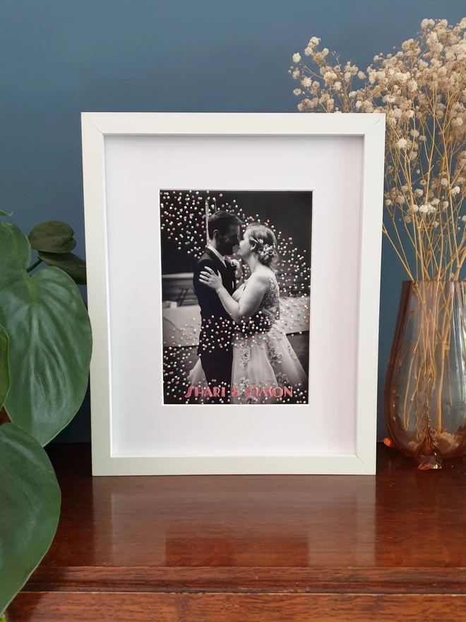  Wedding photo with hand embroidered confetti and name in black frame on desk