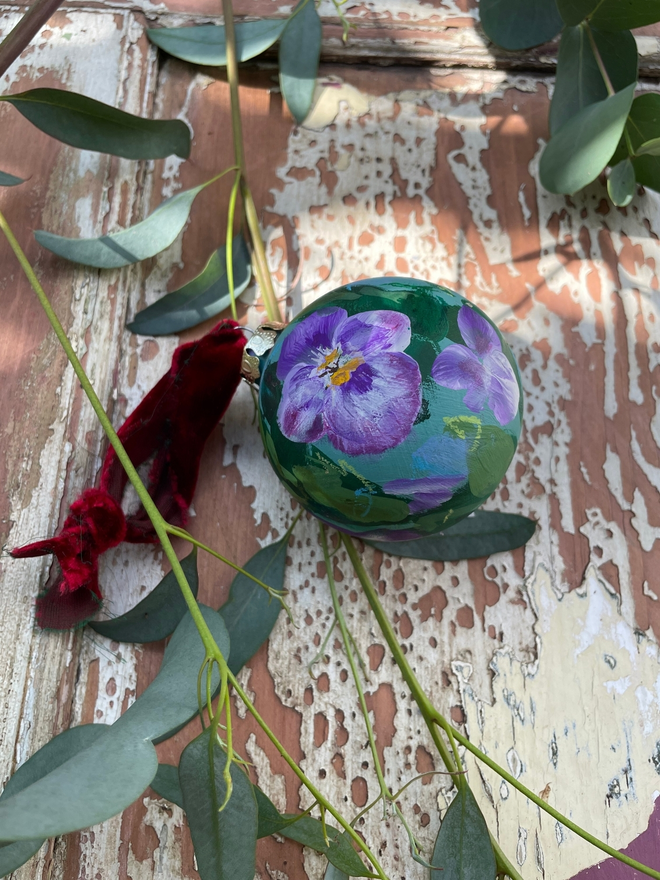 hand painted ceramic floral christmas bauble ornament decoration cornflower blue background purple pansy viola flowers