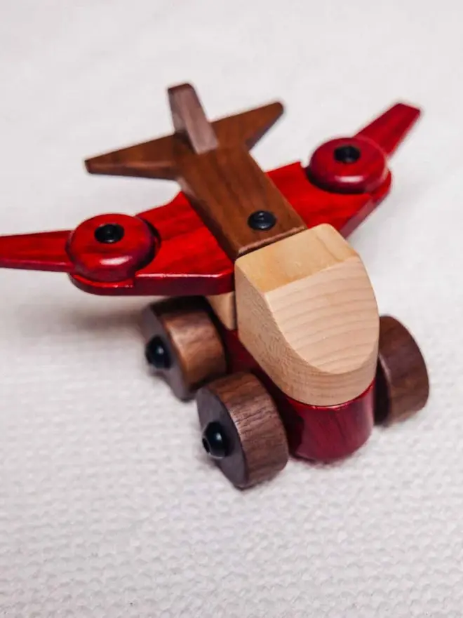 Walnut & Padauk Aeroplane Wood Heirloom Toy, on a table. 