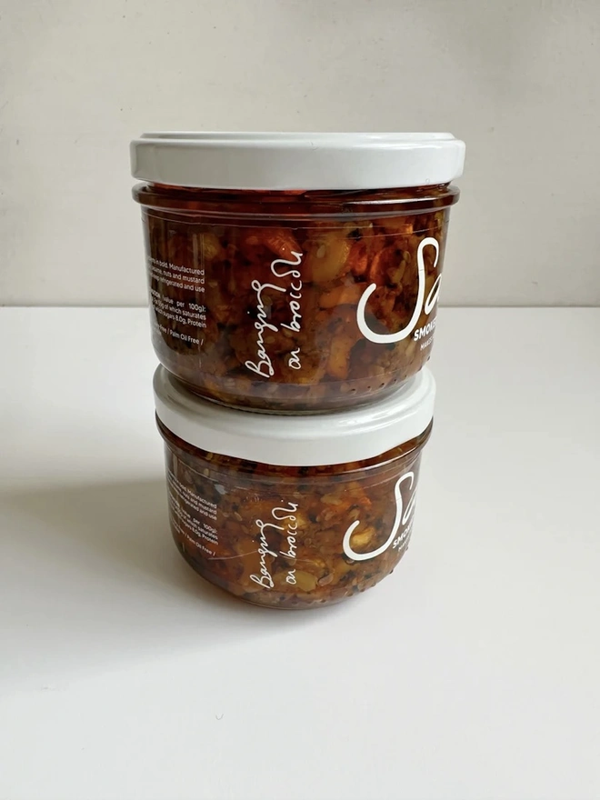 Smoked Cashew (Set Of 2), a pair of smoked cashew sauces sitting on a white table in front of a grey backdrop. 