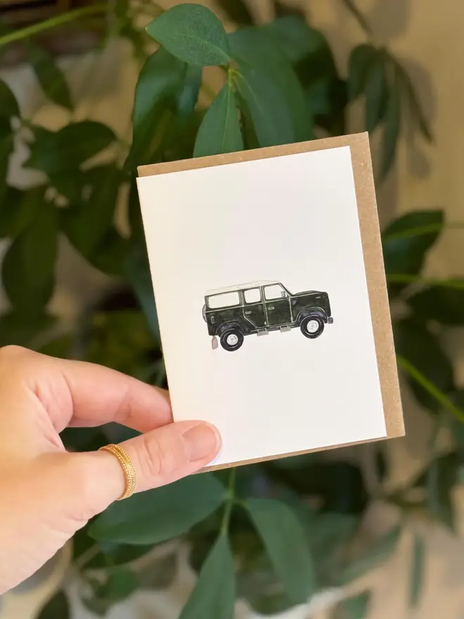 land rover defender illustrated mini card. card photographed with houseplant in background.