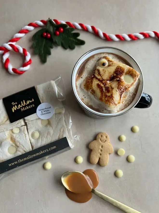 The-Mallow-makers-looking-down-on-hot-chocolate-with-gingerbread-and-white-chocolate-marshmallow-beside-packet-and christmas-ribbon