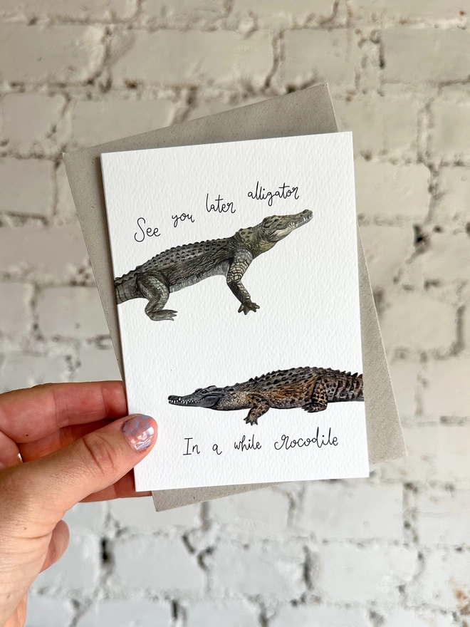 greetings card featuring an illustrated alligator and a crocodile and the phrase “see you later alligator, in a while crocodile”