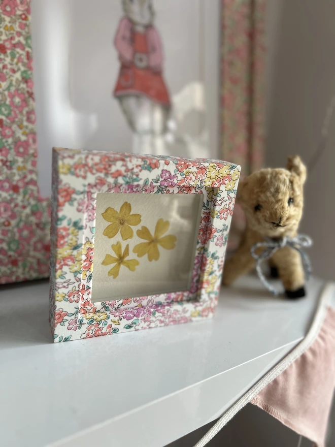 Liberty fabric mini box mount frame displayed on shelf in nursery