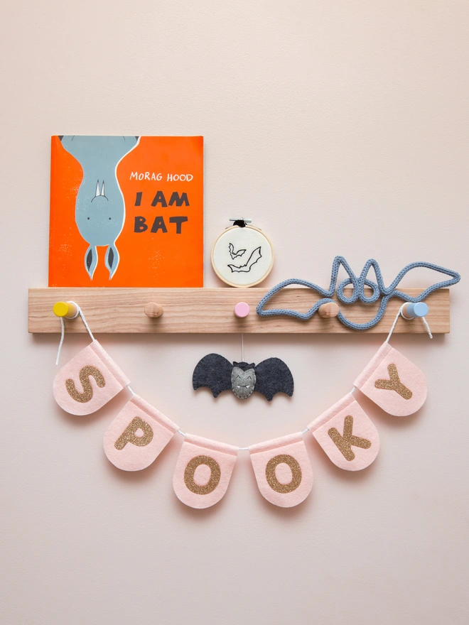 blush pink, felt scalloped halloween bunting with text that reads "SPOOKY" written in champagne glitter felt.