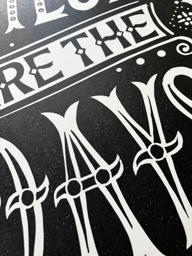 these are the days linocut. a linocut phrase printed on black paint.