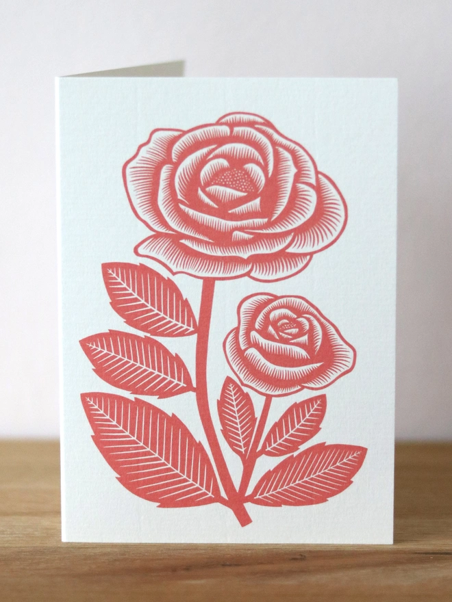 A greetings card with a red rose design based on an original linocut print