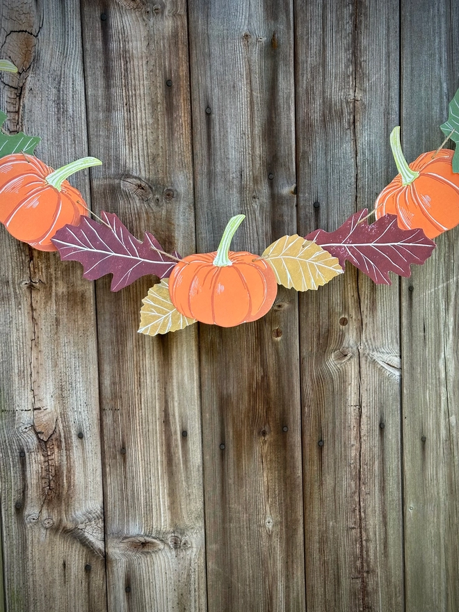 Hand Printed Linocut Pumpkin with oak leaves on a bunting string. Movable components, each one printed individually.Autumn Leave each side of the pumpkin.