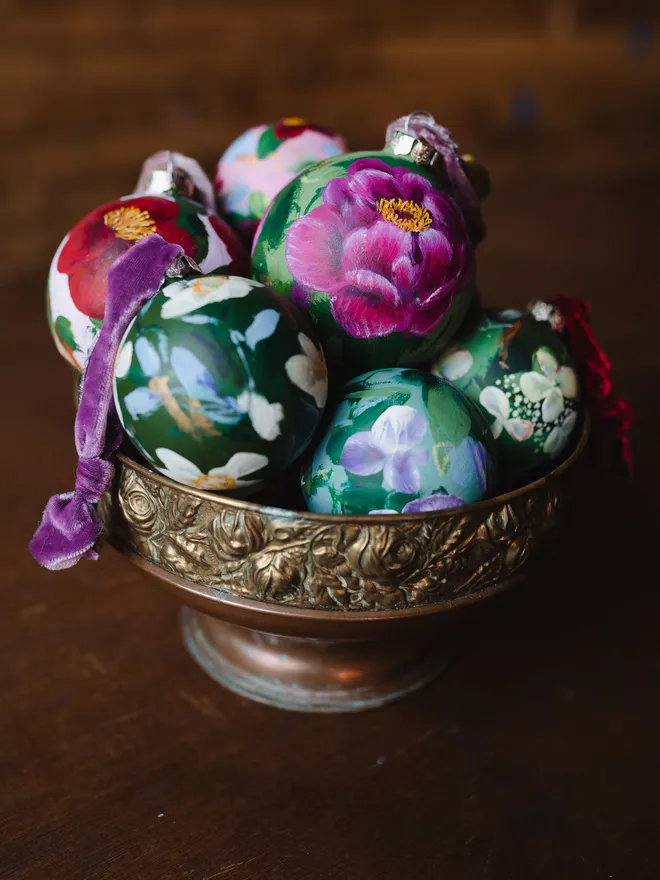 bowl of hand painted heirloom floral ceramic Christmas baubles 