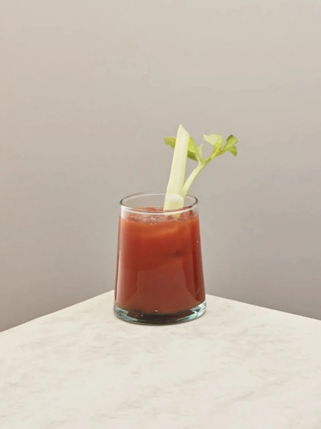 Tumbler Glasses (Set Of 1 Or 4), a tumbler glass sitting on a plain counter top against a plain backdrop. The glass contains a soft drink in it. 