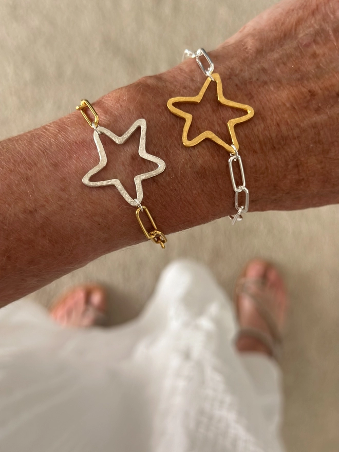 model wears a rustic gold plate open star charm on silver paperclip chain bracelet