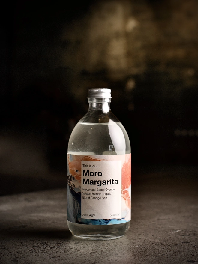 A bottle of Moro Margarita shown against a moody interior background