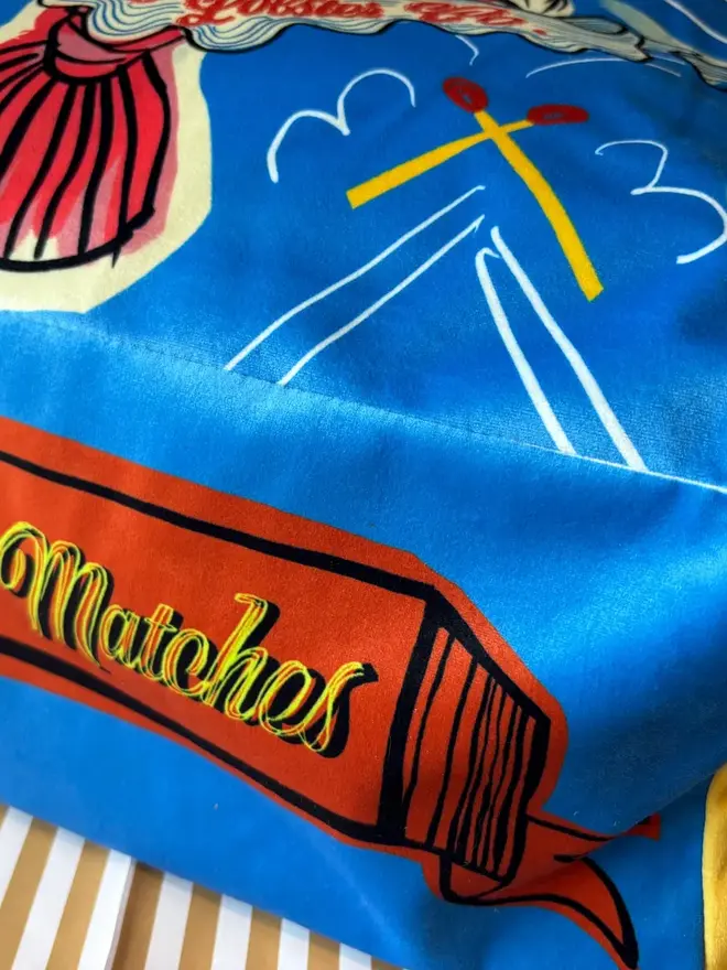 Lobster Matchbox Cushion, a decorated lobster cushion sitting on an arm chair. 