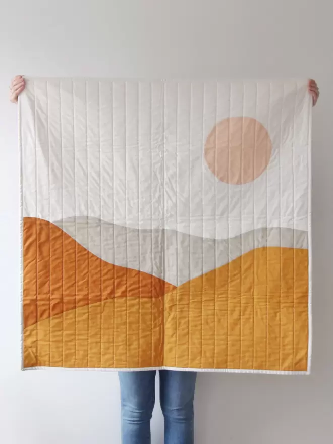 Desert Quilt Being Held Up