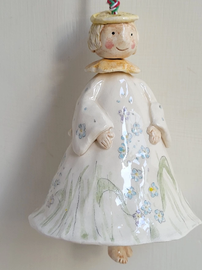 angel bell with forget me not flowers in white ceramic
