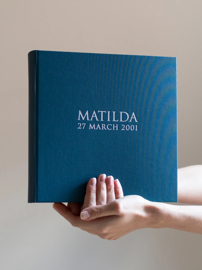 Beautiful Personalised Photo Album for Birthday or New Baby being held up. It has a name printed on the front in capital letters.
