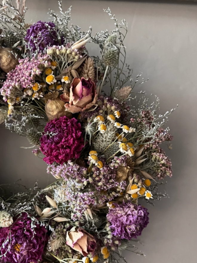Autumnal Everlasting Wreath. A wreath made of seasonal autumnal flowers and plants, hung on a wall.