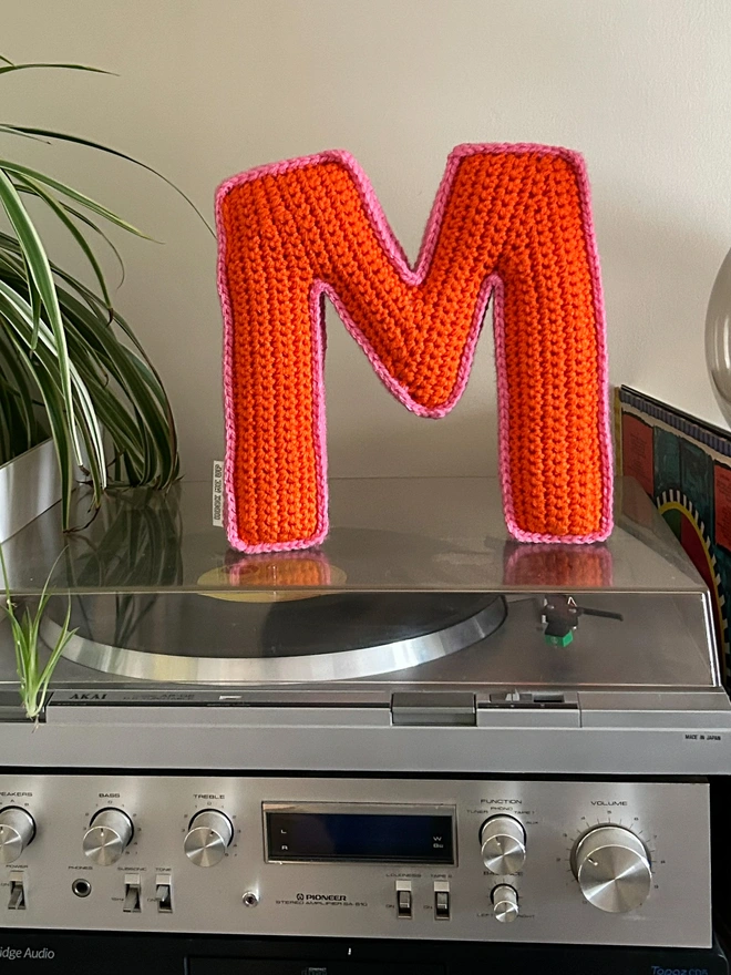 Crochet letter cushion shaped like an M