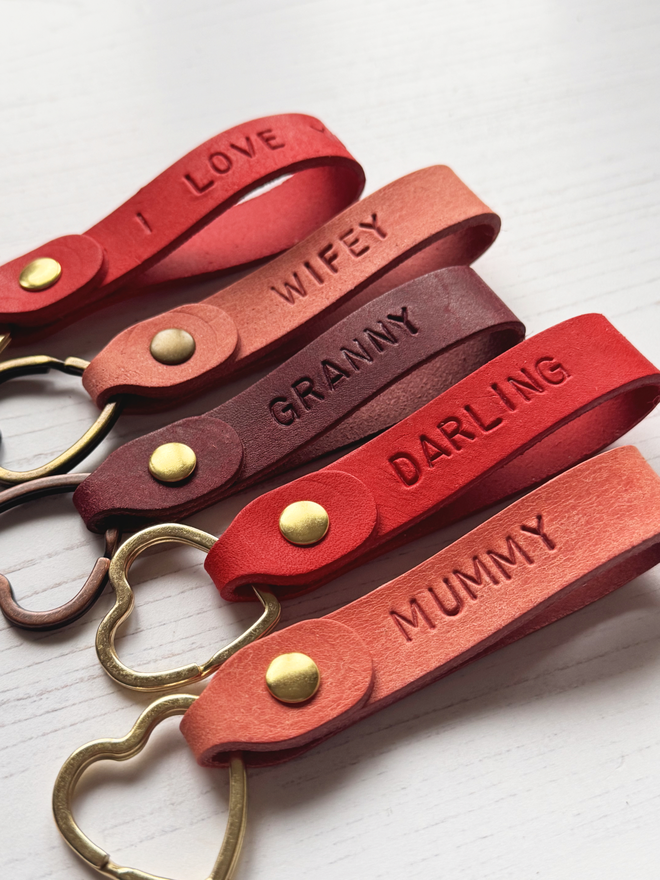 hand stamped leather loop keyring in pink, red and burgundy on a white background.