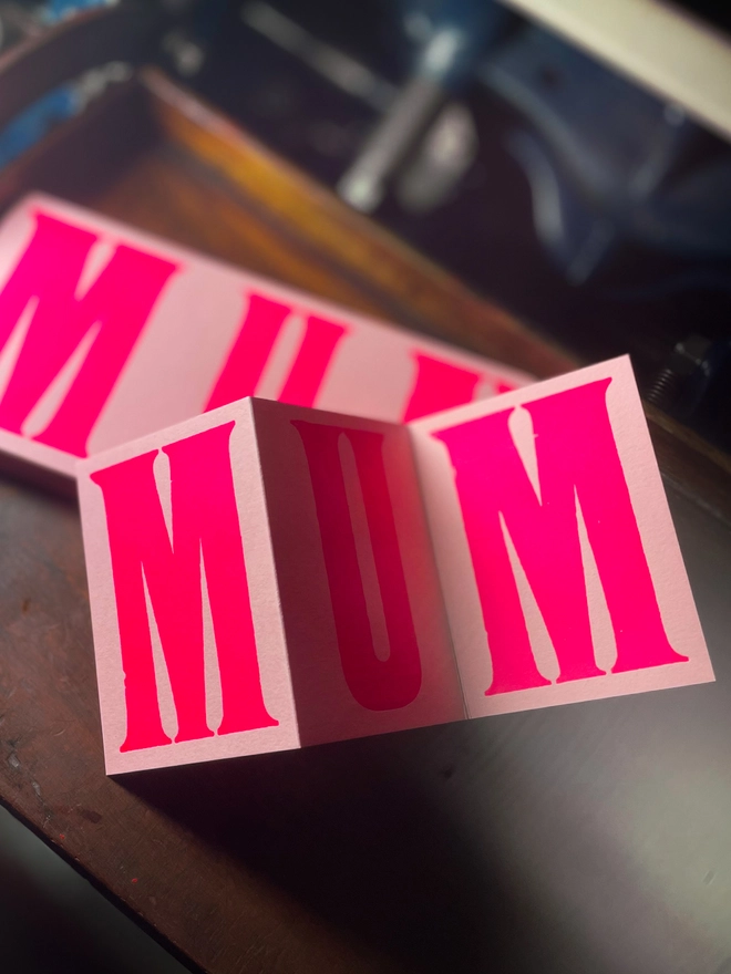 An artisan Mother’s Day concertina card printed in bold Runic Grotesque type using fluorescent pink ink on thick GF Smith Colorplan Candy Pink card, letterpress printed with a deep impression.