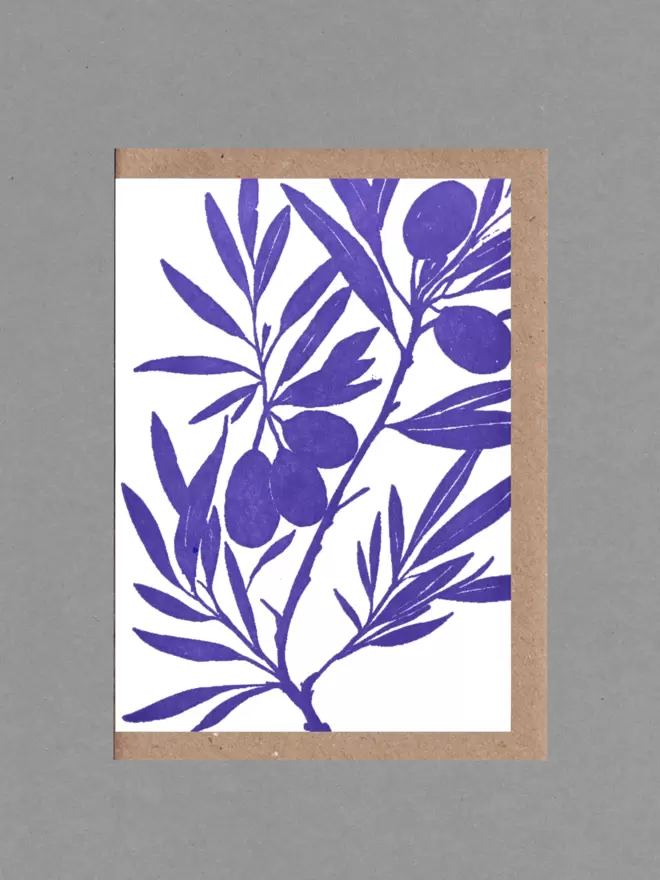 Greetings card with an illustration of olive branches in purple. Behind the card is a brown envelope with a grey backround.