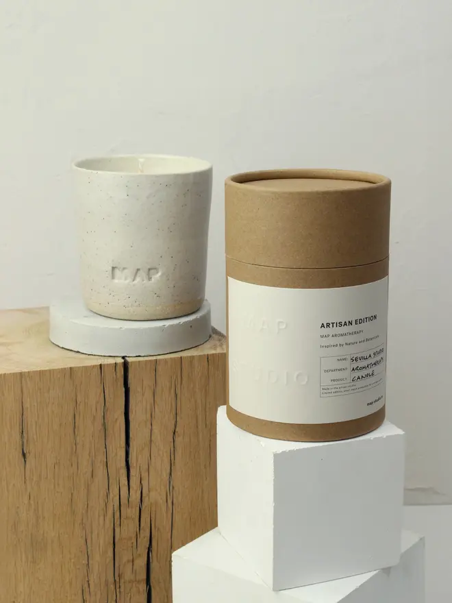 'St Helena' Soy Wax Candle And Ceramic Holder. candle and packaging box photographed on small wooden platforms.
