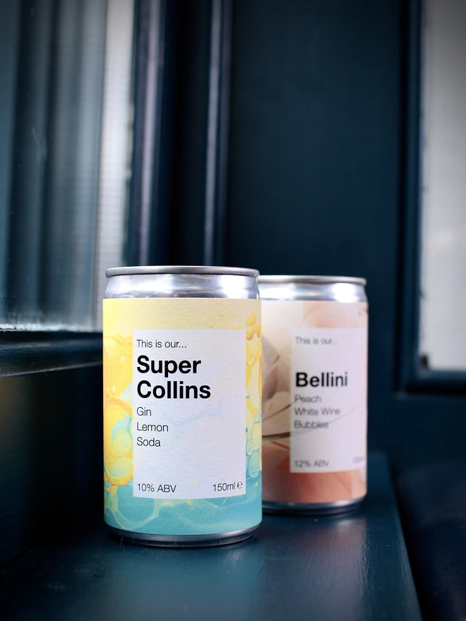 Super Collins and Bellini cans with a blue background