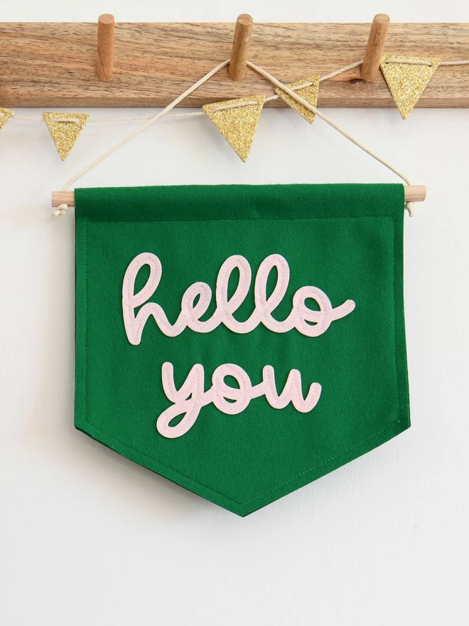 mini green felt banner with hello you sewn on in baby pink felt.