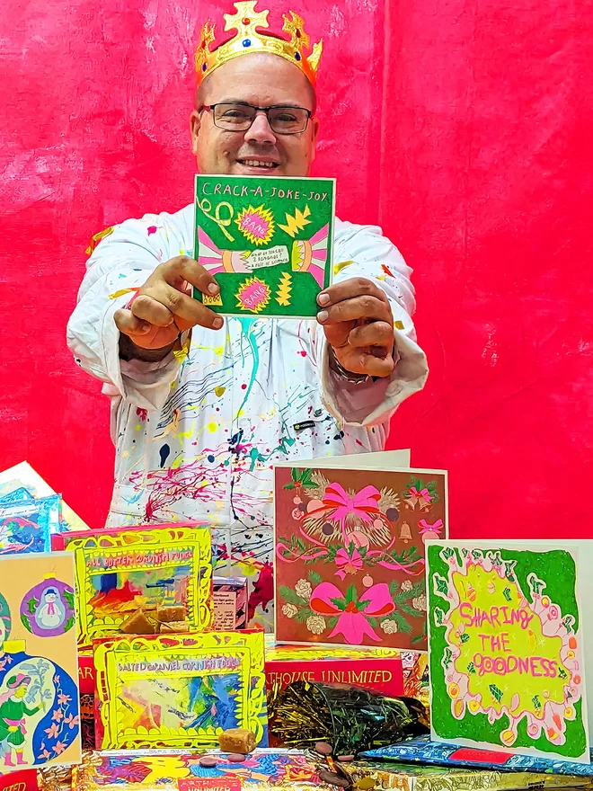 Artist holding a handmade riso printed Christmas Holiday greeting card, Crack a Joke Joy 