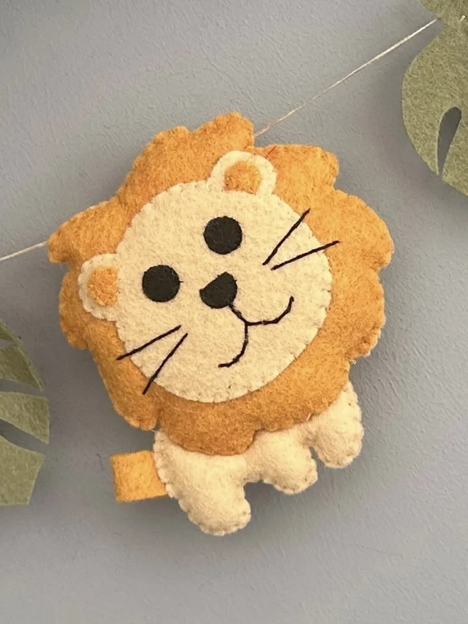 Nursery Safari Garland, a safari themed garland hanging in a child's bedroom against a grey backdrop. 