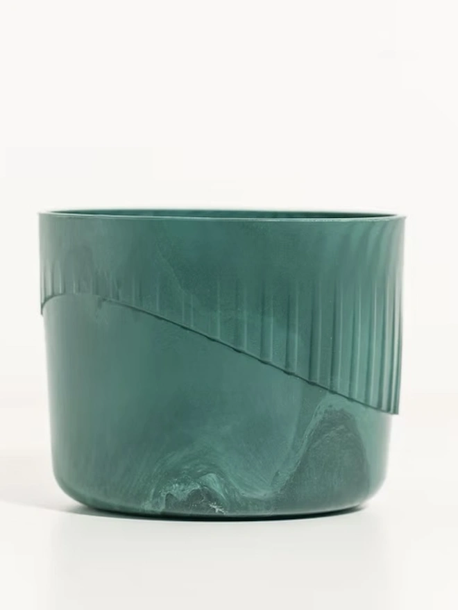 Ocean Plastic Plant Pot Small, a green recycled plant pot sitting on a white surface against a plain backdrop. 
