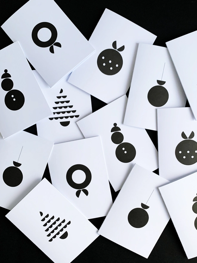 Group of scattered Christmas Cards with Christmas Icons on them in black and white