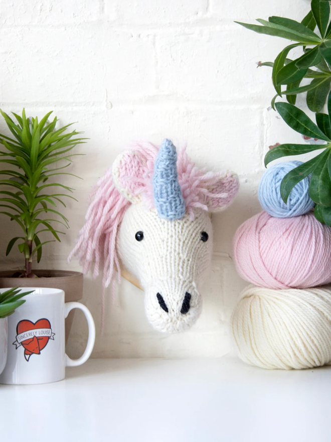 Mini Unicorn Head Knit Kit. A unicorn head with pink hair and a blue horn