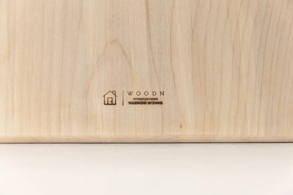 Sycamore Square Serving Board, a serving board sitting on a plain surface against a plain backdrop. 