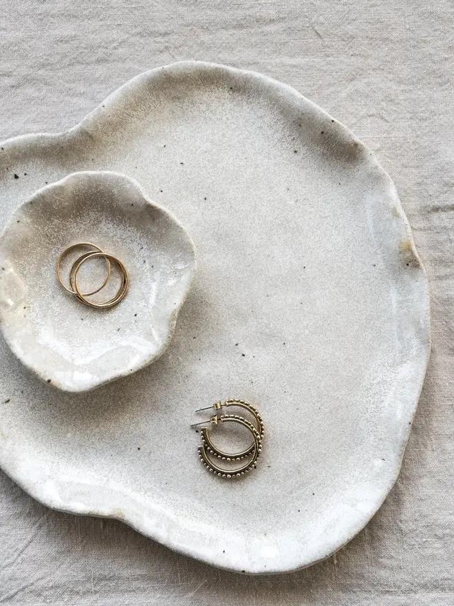 Lily Pad Jewellery Dish In Sea Salt Glaze, dishes stacked on top of each other with rings in them, on a table cloth. 