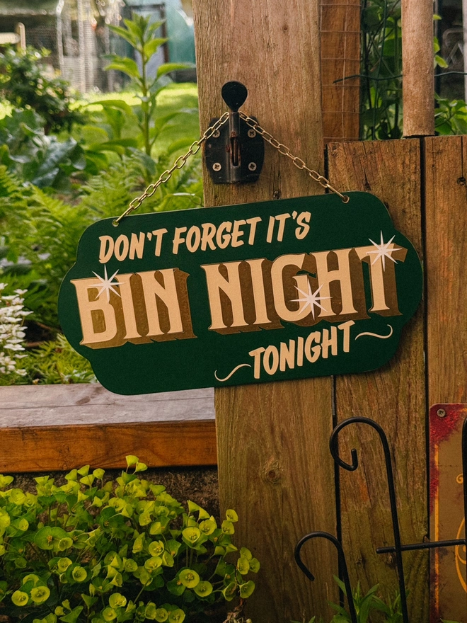 green 'dont forget it's bin night tonight' sign with gold text and hanging chain