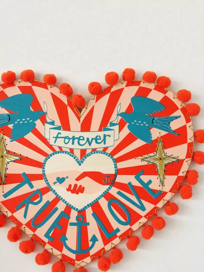 A romantic, nautical, colourful wooden screen printed heart, reading 'true love forever'