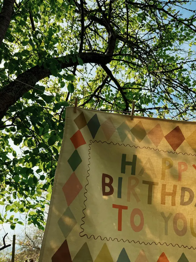 Heirloom Fabric Birthday Banner, hanging in a tree. 