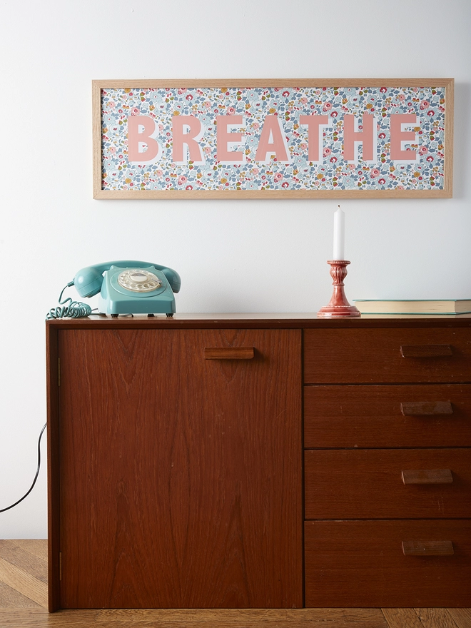 Personalised word/name framed picture in salmon pink with white highlights on Liberty Betsy blue fabric